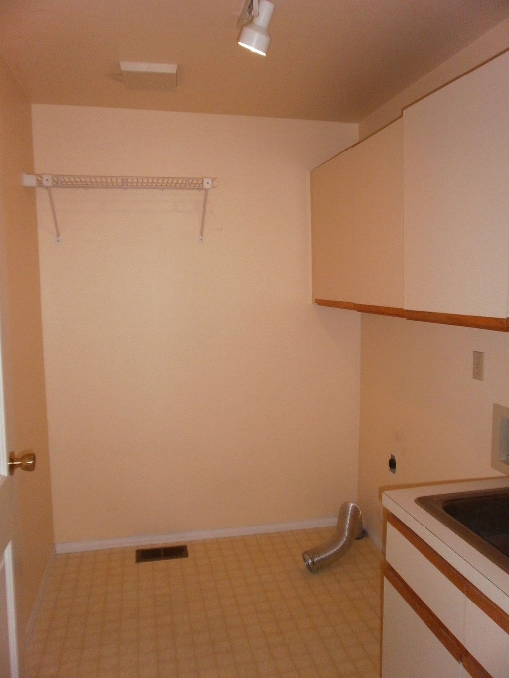 an empty kitchen with white cabinets and a sink