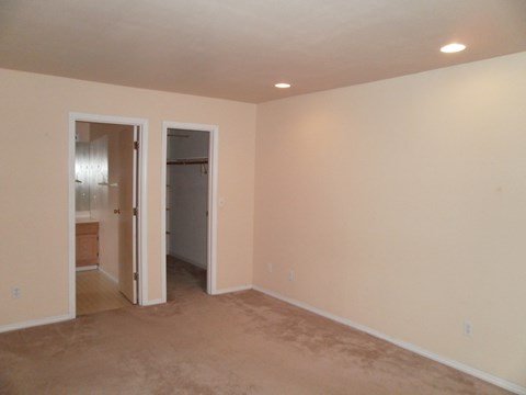 a living room with a carpet and a door to a bathroom