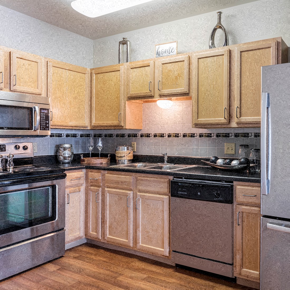 A kitchen with wooden cabinets and black countertops.