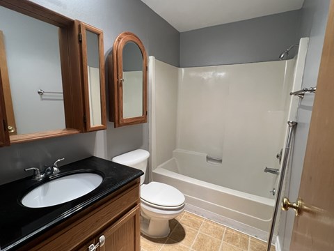 A bathroom with a toilet, sink, and bathtub.