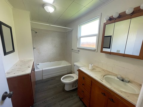 A bathroom with a toilet, sink, and bathtub.