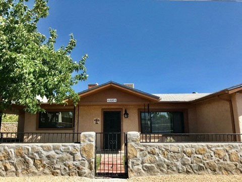 a house with a stone wall and a gate