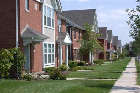 a row of brick houses next to a sidewalk