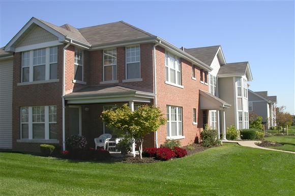 a large brick house with a lawn in front of it