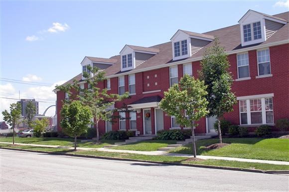 a red brick house with trees in front of it