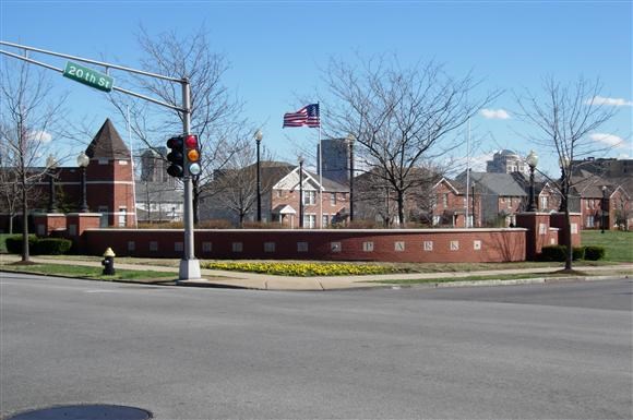 a street corner with a traffic light and a brick wall
