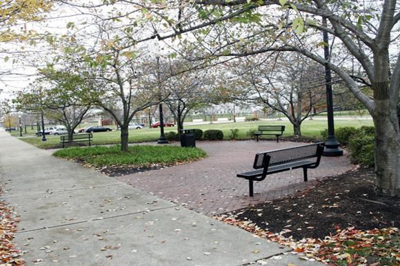 a park bench sitting on a sidewalk in a park