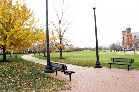 two benches in a park next to two street lamps
