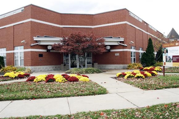 a brick building with a flower garden in front of it