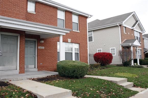 a sidewalk in front of a brick house