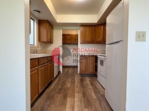 A kitchen with wooden cabinets and a white refrigerator.