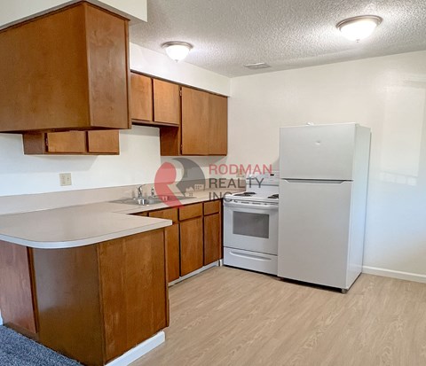 A kitchen with wooden cabinets and a white refrigerator.