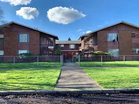 A residential area with houses and a fenced pathway.