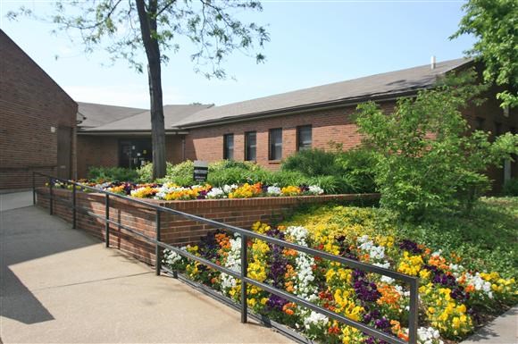 a garden of flowers in front of a building