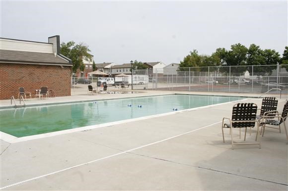 a swimming pool with chairs and chairs around it