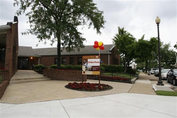 a sidewalk in front of a building with balloons