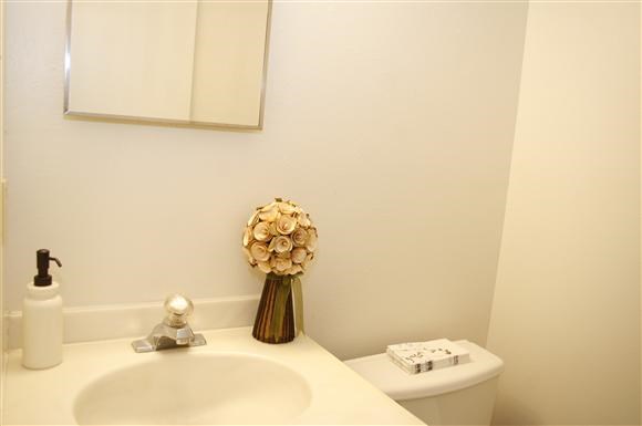 a bathroom with a white sink and a vase with flowers