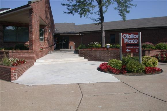 a sidewalk in front of a building with a sign