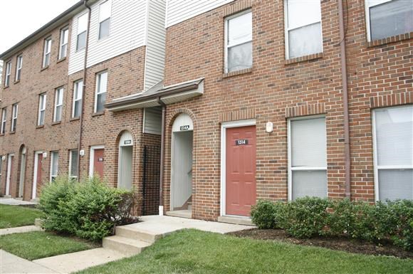 a brick apartment building with a red door