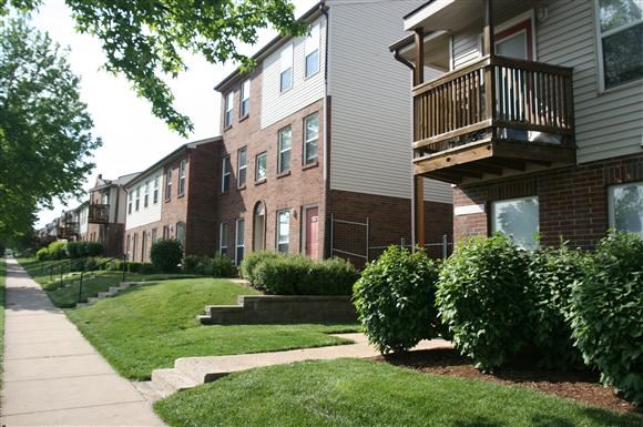 a row of houses with a balcony and a sidewalk