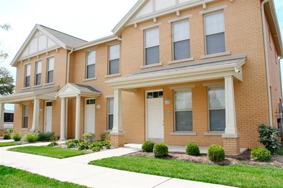 a brick house with a sidewalk in front of it