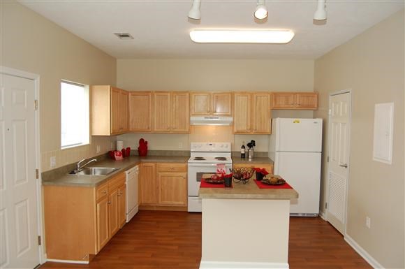 a kitchen with white appliances and wooden cabinets