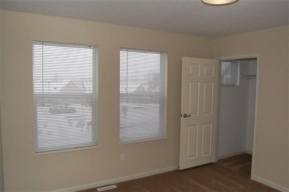 an empty room with two windows and a white door