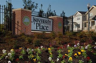 a sign for university place in front of a garden
