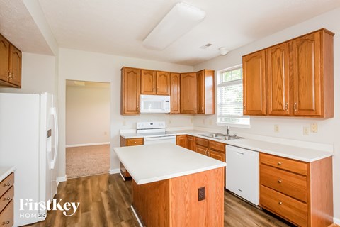 A kitchen with wooden cabinets and a white fridge.