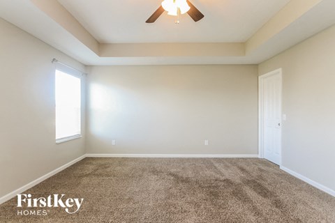 a living room with carpet and a ceiling fan