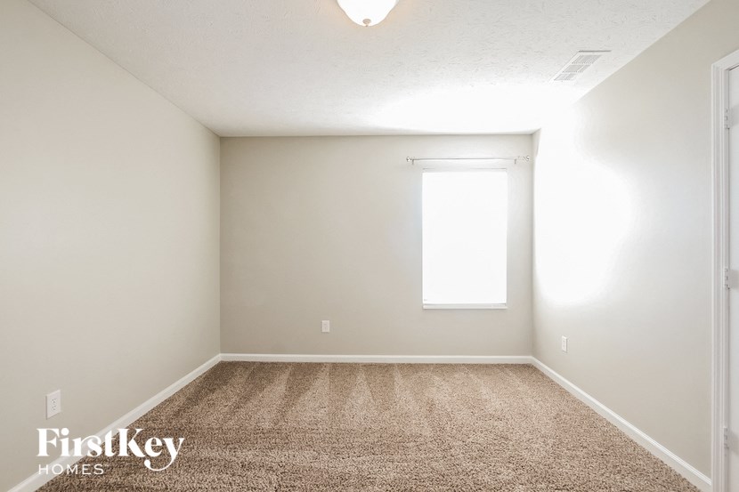 a empty room with carpet and a window