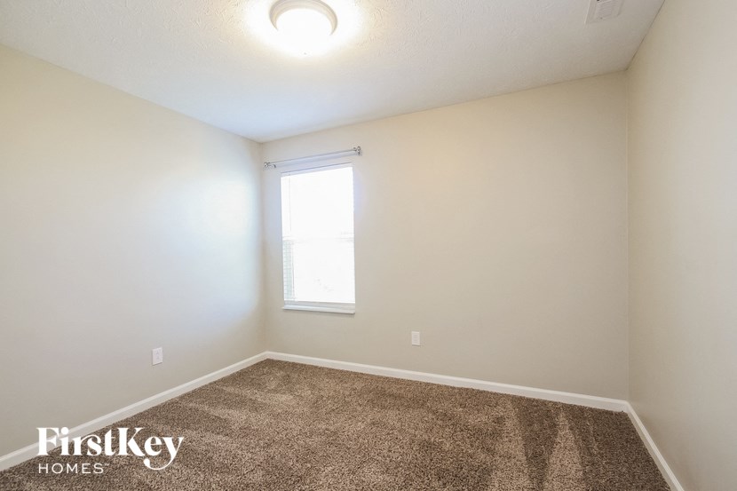 an empty room with a window and carpet