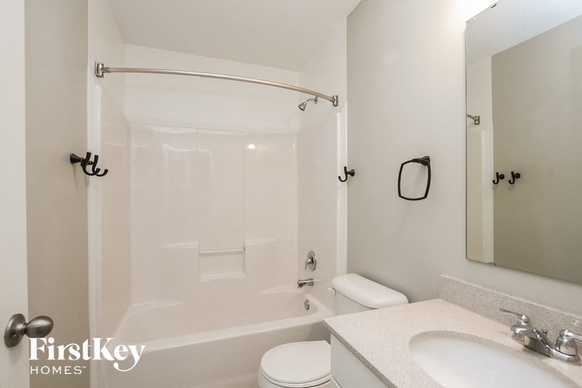 a white bathroom with a white toilet and a tub and a sink