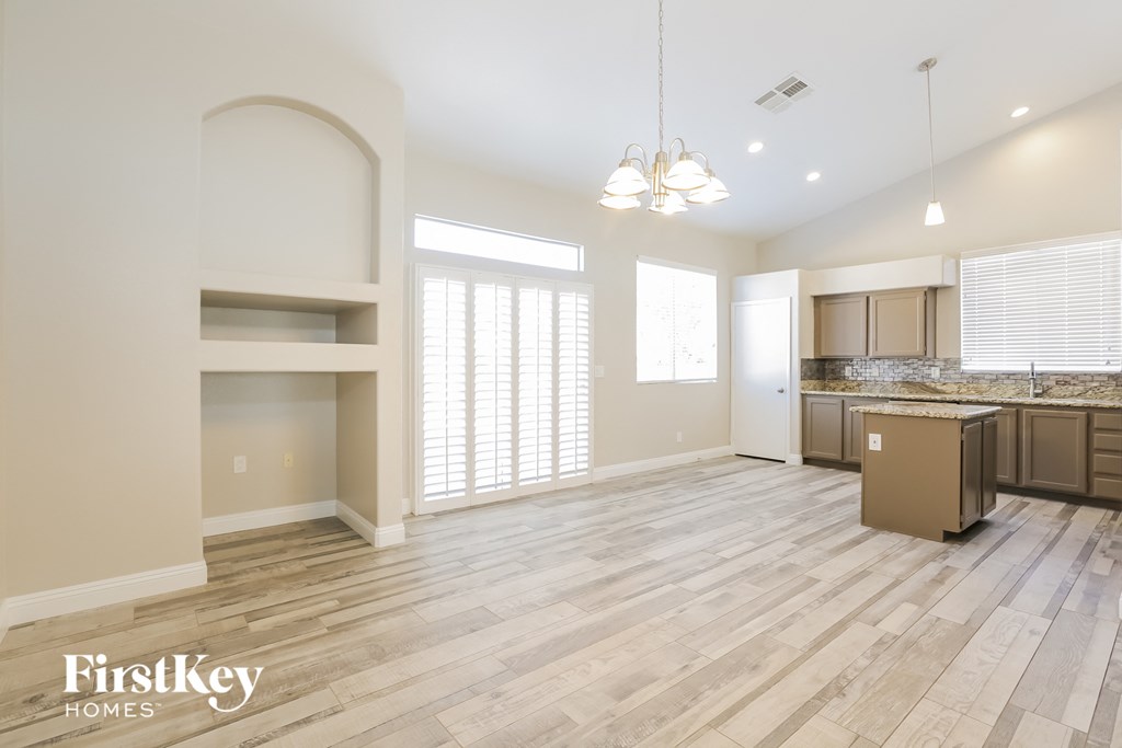 A spacious kitchen and living room with wooden flooring and a large island.