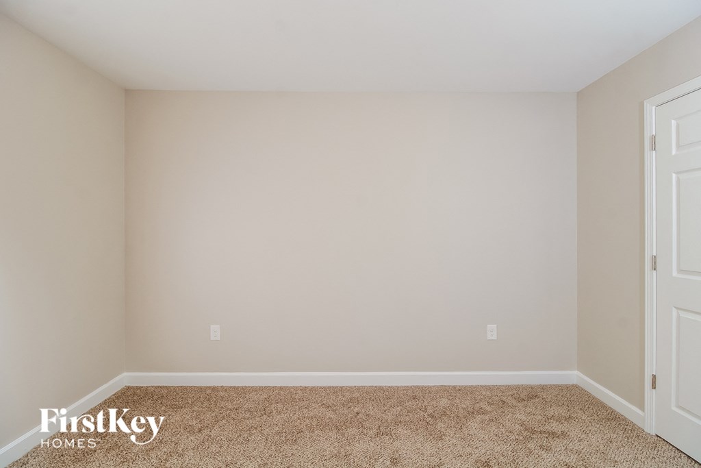 a empty bedroom with a carpeted floor and two doors