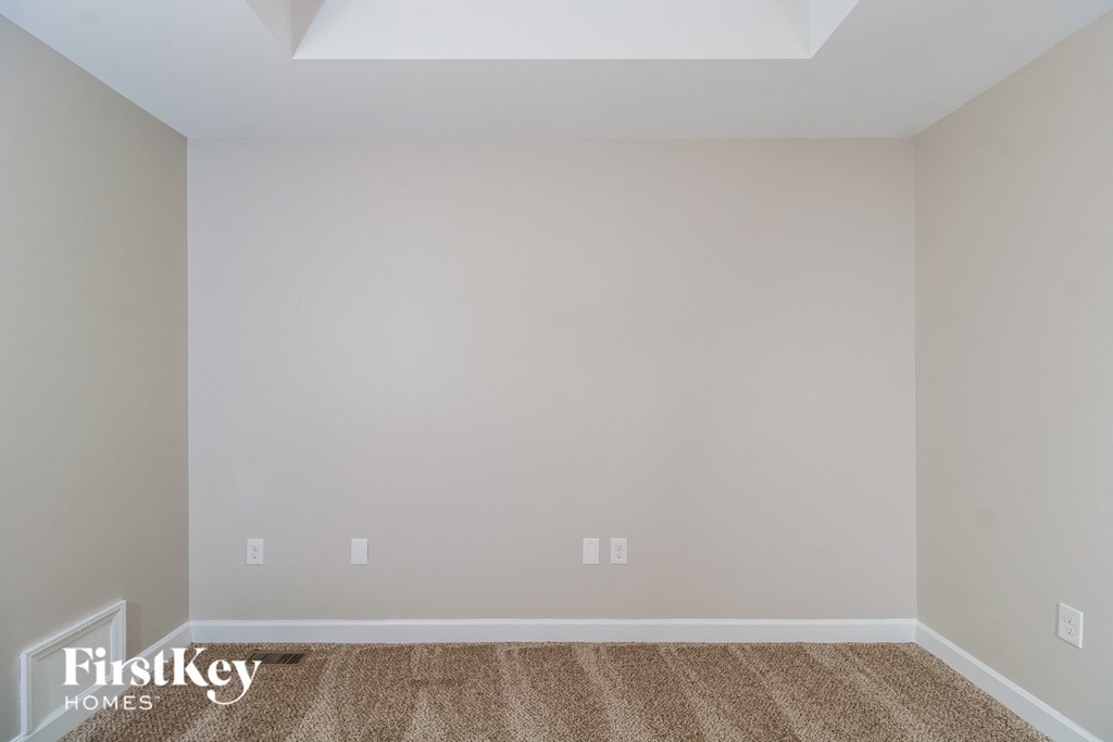 the living room of an empty house with carpet and white walls