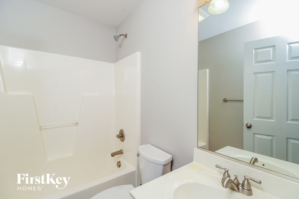 a bathroom with a white sink and a mirror and a toilet