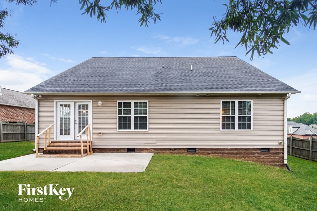 a small brown house with a yard and a porch