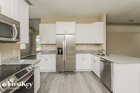 A kitchen with white cabinets and stainless steel appliances.