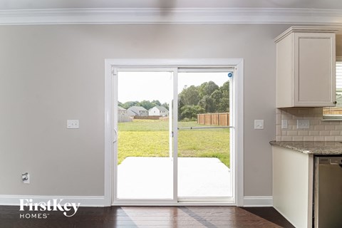 a kitchen with white cabinets and a sliding glass door