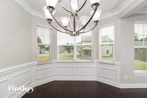 a dining room with a large window and a chandelier