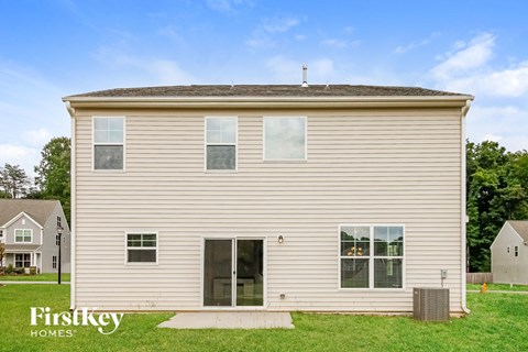 the backyard of a house with white siding and grass