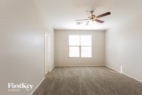 a living room with carpet and a ceiling fan