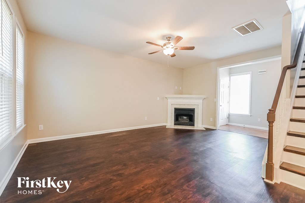 A spacious living room with wood flooring and a fireplace.