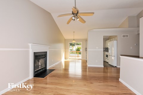 a living room with a fireplace and a ceiling fan