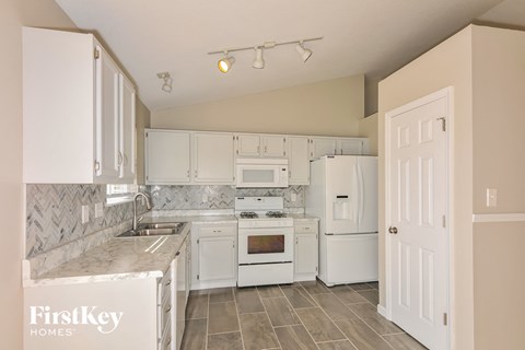 a kitchen with white appliances and white cabinets