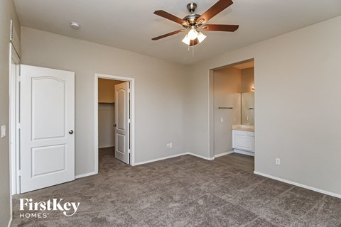 a living room with carpet and a ceiling fan