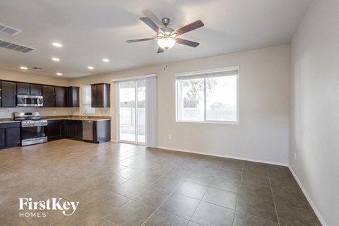 an empty kitchen and living room with a ceiling fan