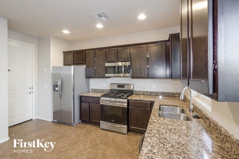 a kitchen with granite counter tops and stainless steel appliances