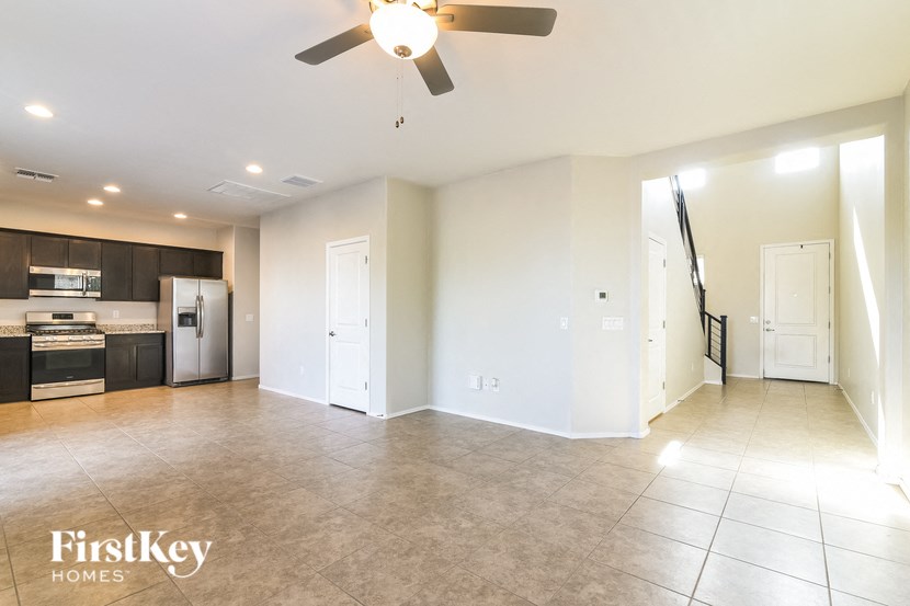 an empty kitchen and living room with a ceiling fan